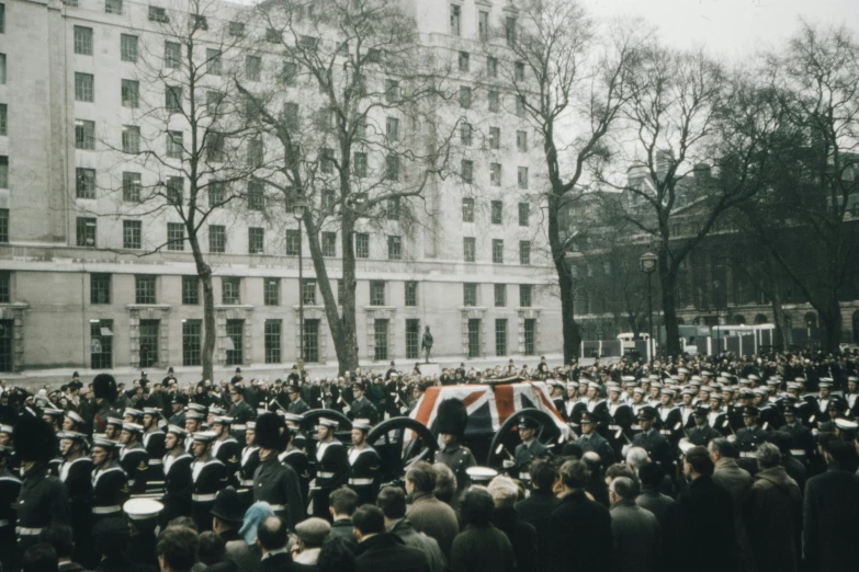 a large group of people are gathered in front of large buildings