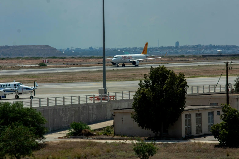 an airplane is taxiing on the runway near two vehicles