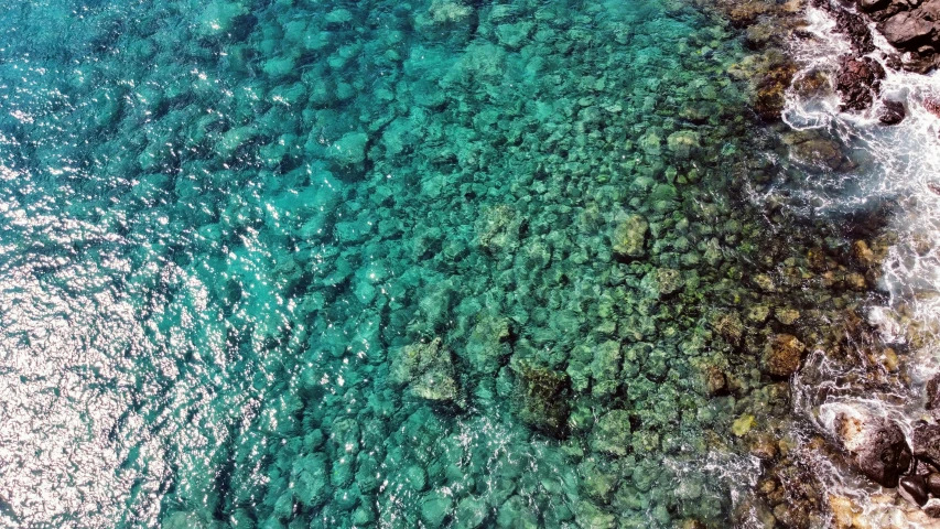 an aerial po of a body of water next to rocky cliffs