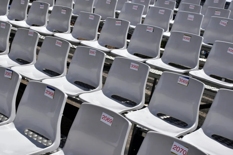 white chairs with labels on them sitting side by side