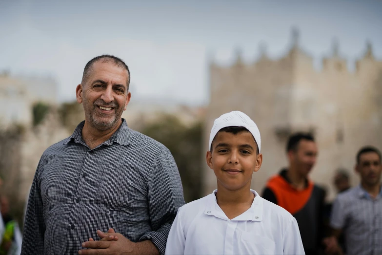 a man in a black and white shirt stands with another man, who has his arms crossed