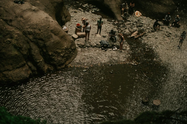 people sitting on rocks and near water