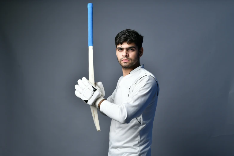 a young man posing for a pograph with a bat