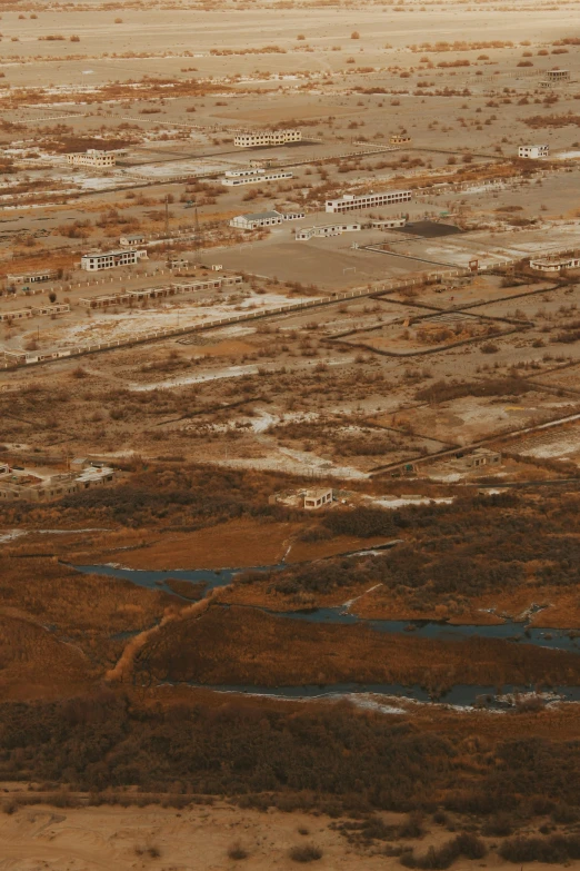 a small airplane flies over a vast brown land