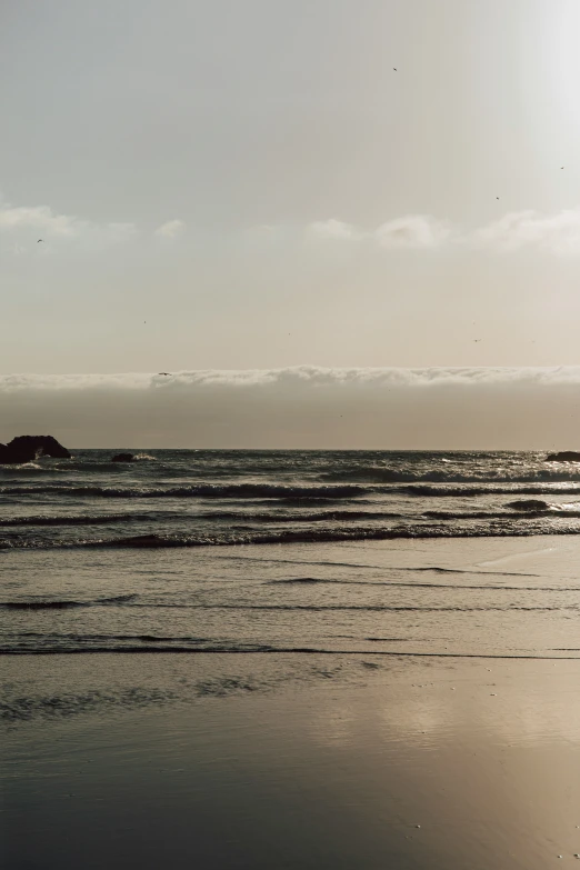 a person is standing on the beach with his surfboard