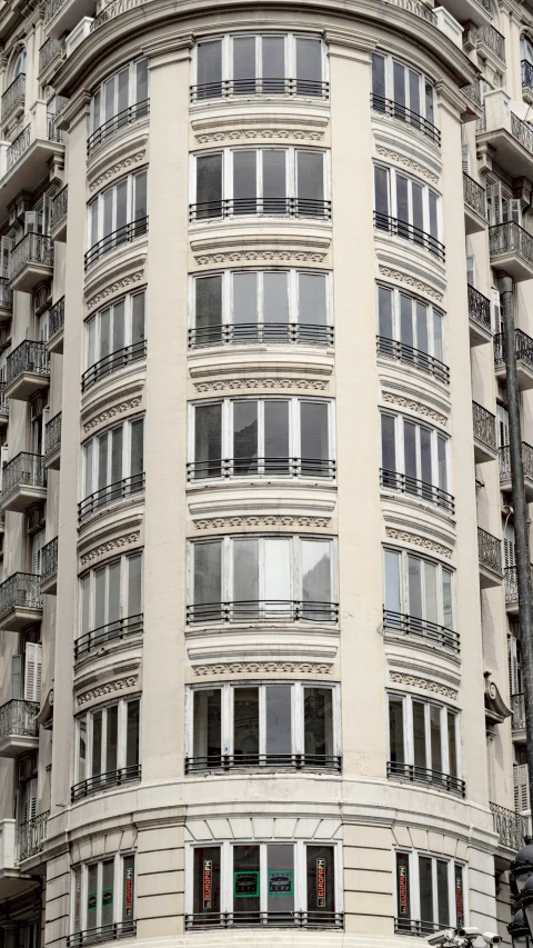 a curved building is filled with windows and balconies