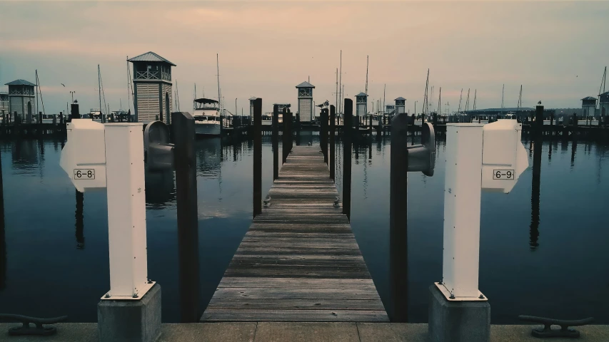 there is a pier on the water with it's lights on