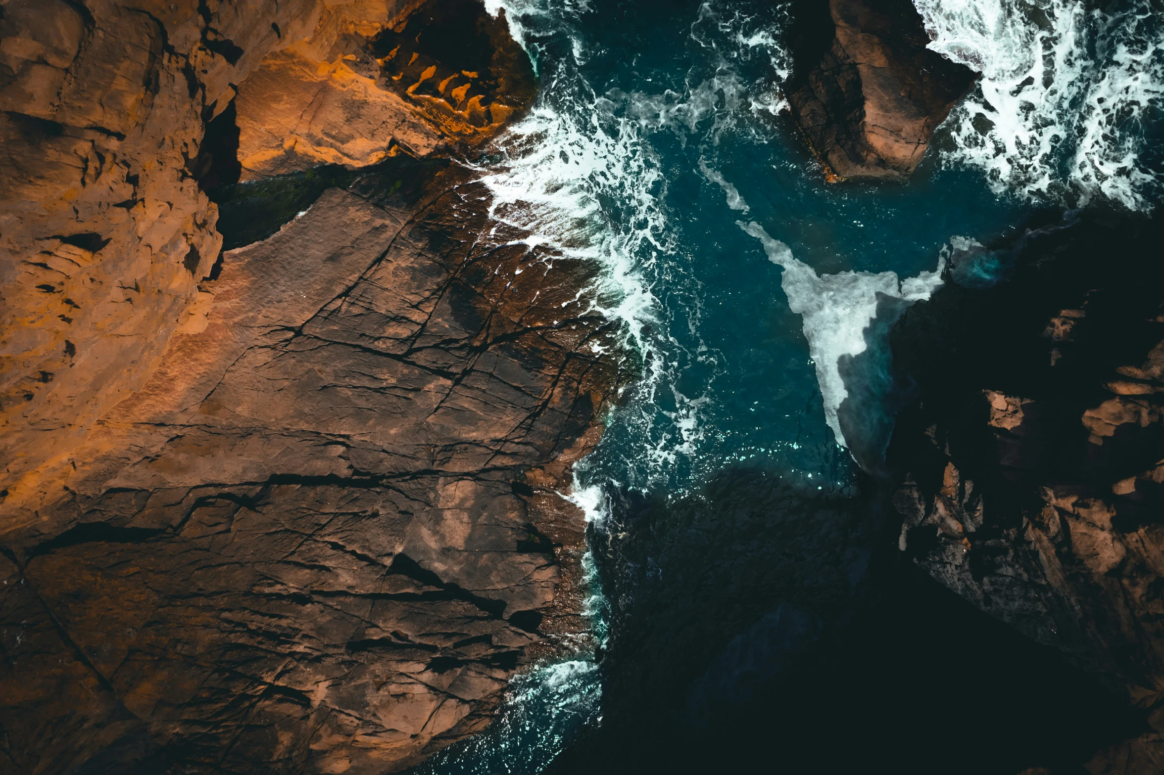 aerial view of rocky and sandy shore by water