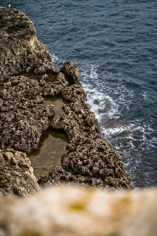 there is a rock tower overlooking the ocean