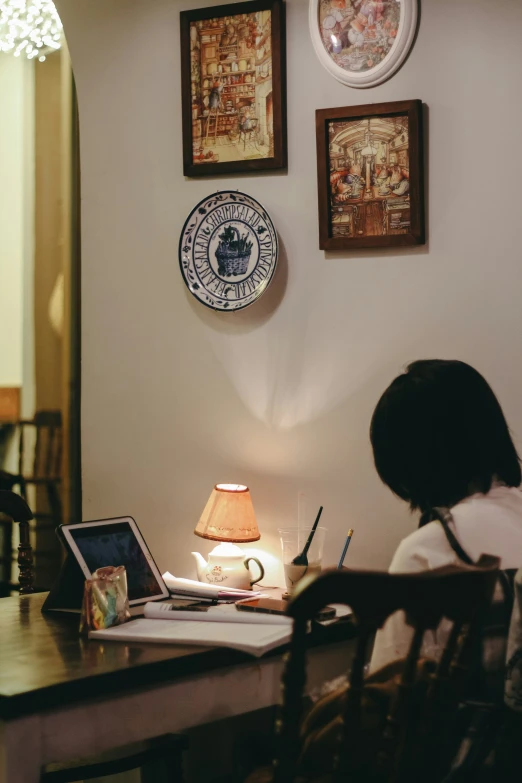 a woman sits in front of a laptop computer