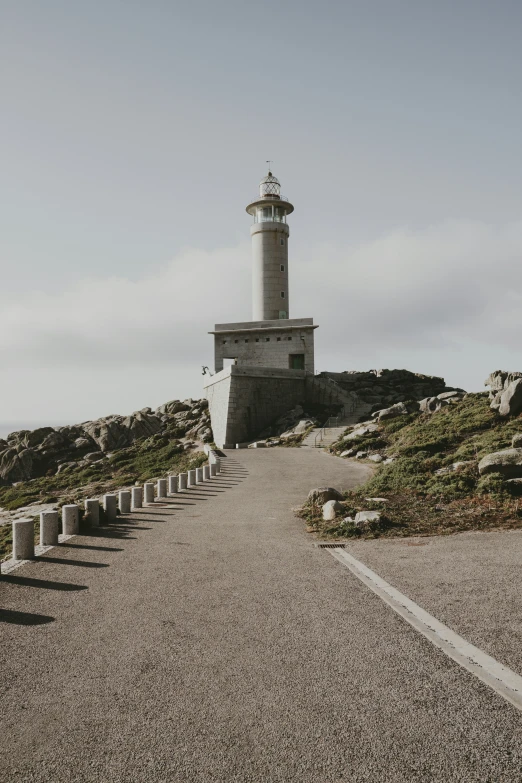 a paved pathway leading to a white lighthouse in the distance