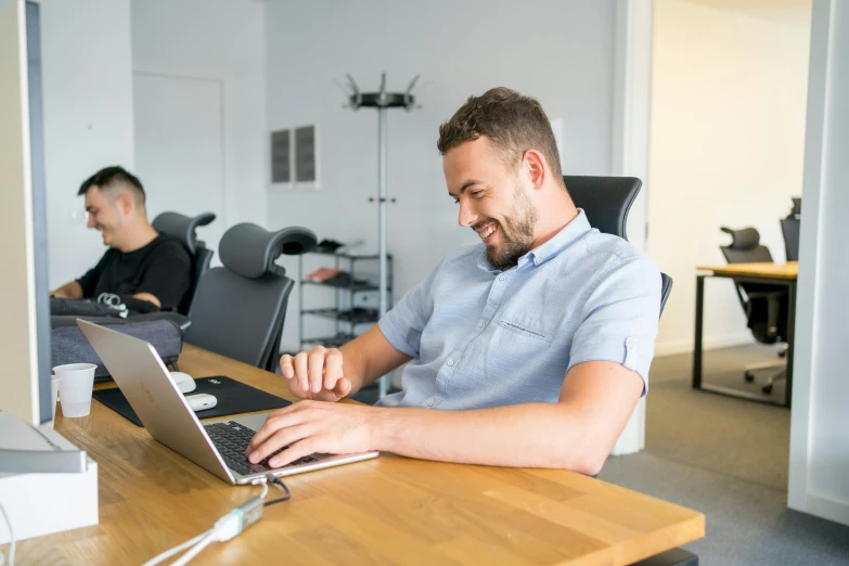 two people work on computers in an office