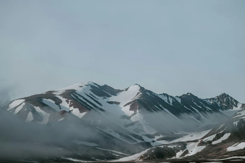 the mountain range, the top of which is covered in white and brown snow