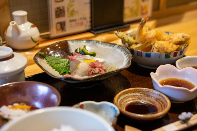 a set of food dishes, sauces, and cups sit on the dining room table