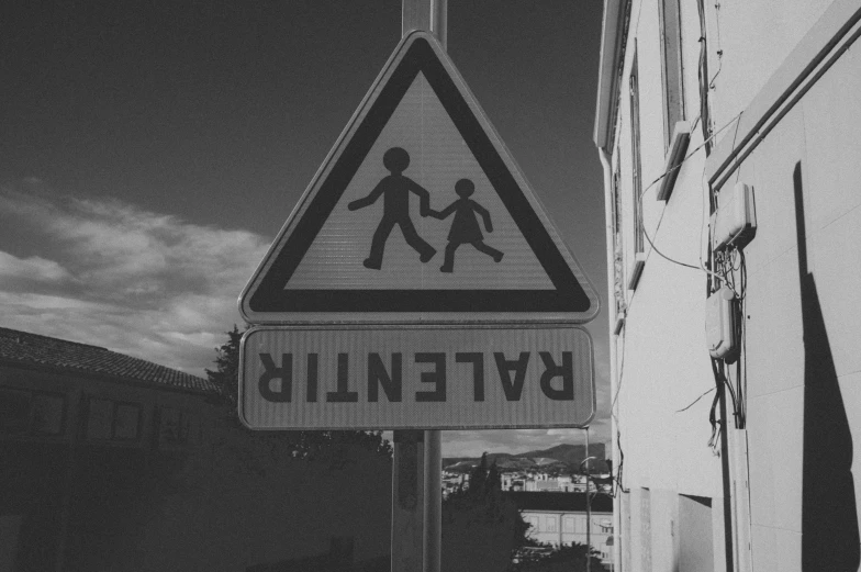a black and white sign showing children walking