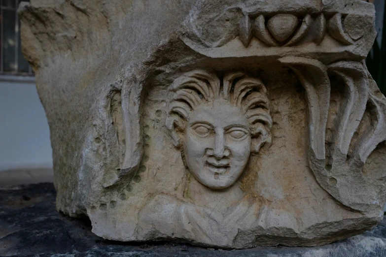 a closeup of a stone sculpture with an interesting face on it