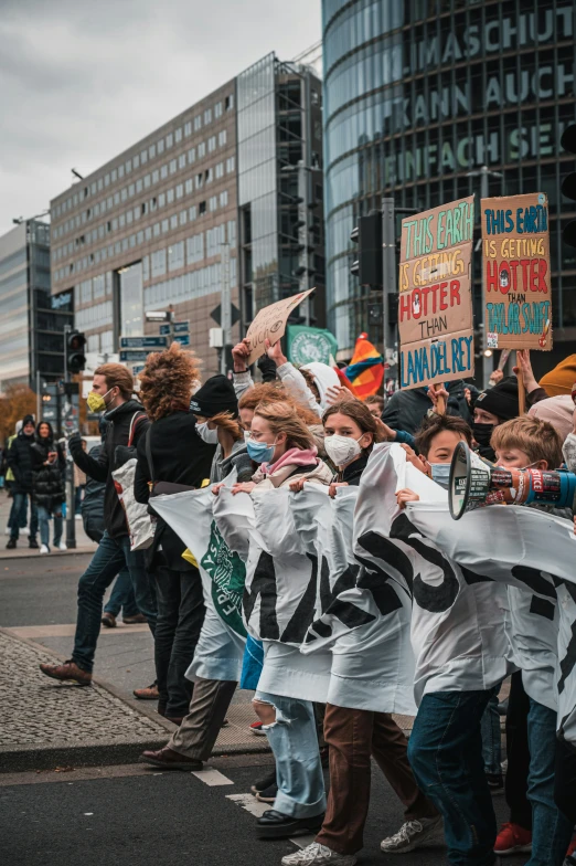 several children walking down a street with signs in hand