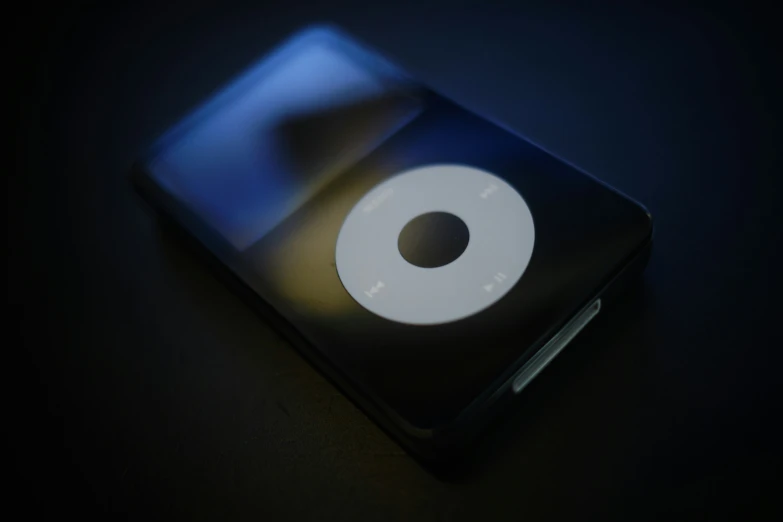 a black ipod is shown with a white disk
