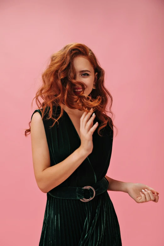 a woman with red hair wearing a black dress and smiling