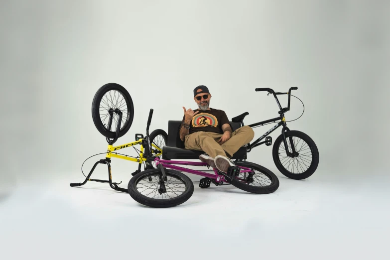 man in glasses sitting on a bike with four bikes mounted to it