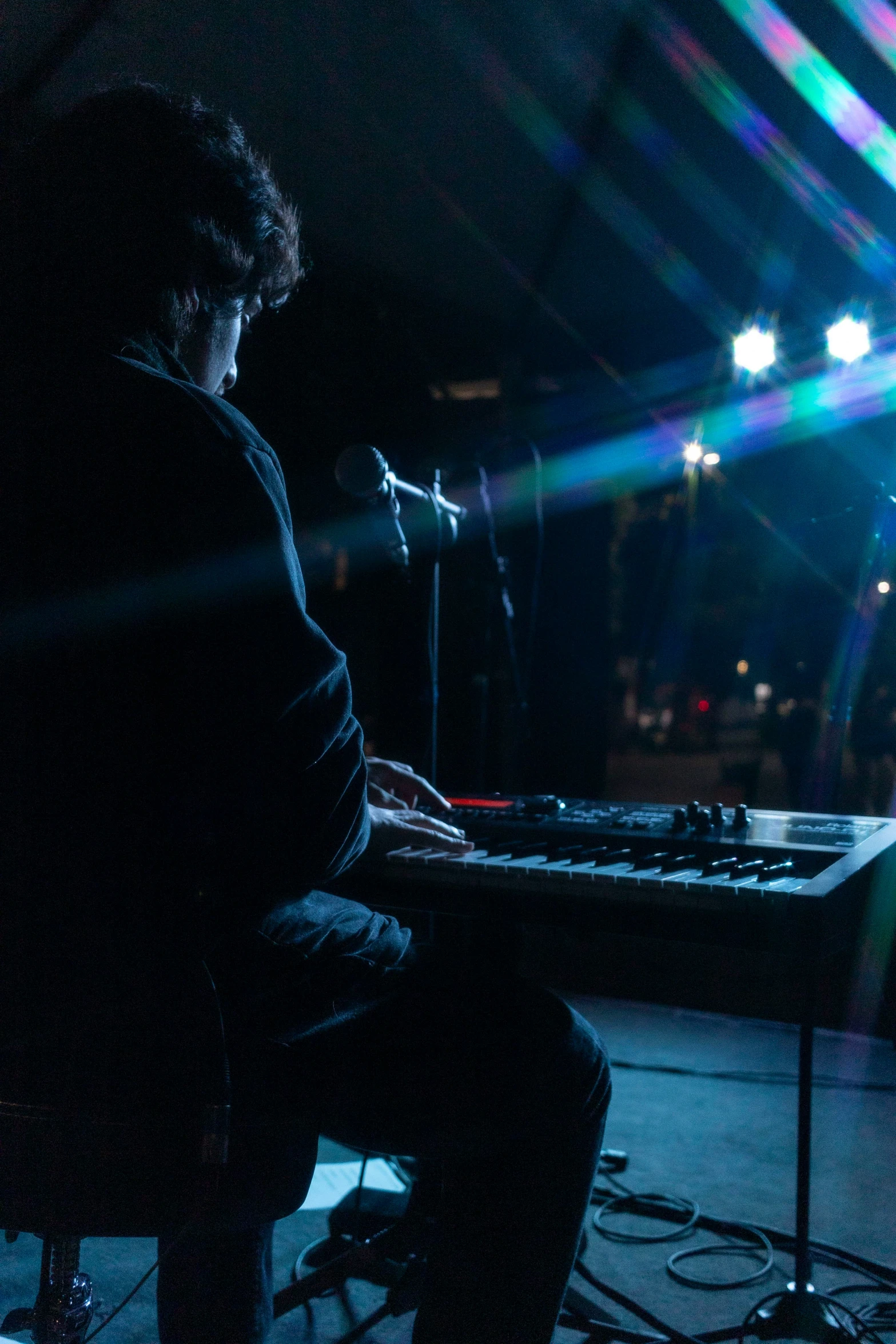 a man sitting on a keyboard in a dark place