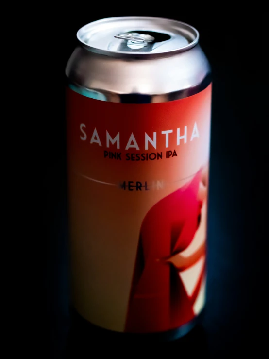 a can of beer in the dark with a red jacket on