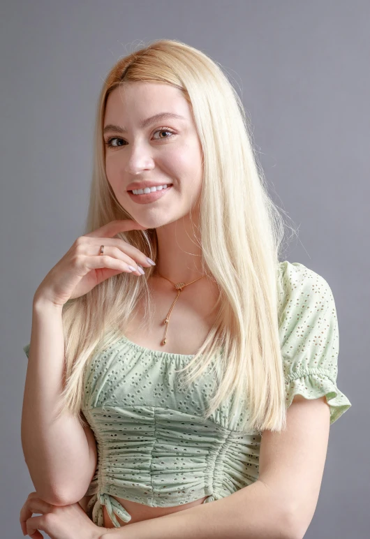 an attractive woman with long blond hair wearing a green dress