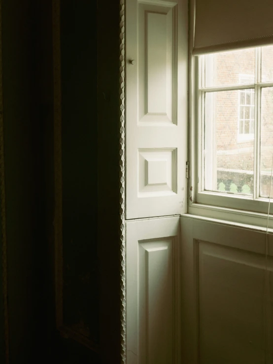 a dark room with a window a small white panel