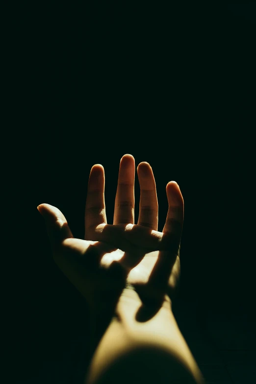 an outstretched hand in a dark area