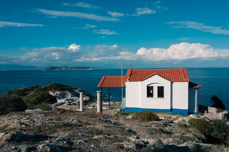 there is a small white house next to the ocean