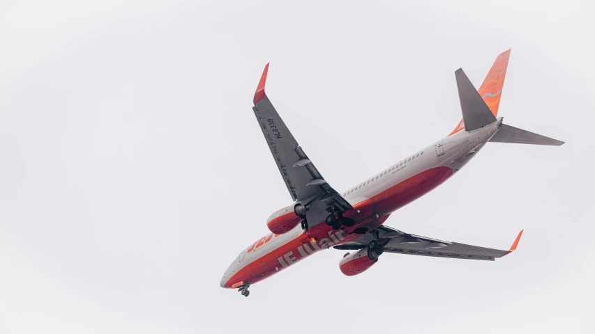 a red, white, and blue airliner in flight