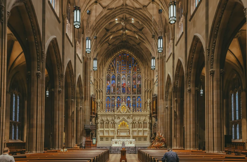 the inside of a church, with two people looking at the alter