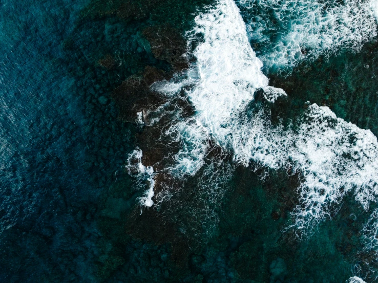 aerial view of waves in water on a sunny day