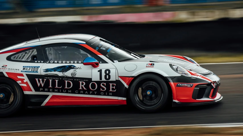 a car driving on a race track with wild rose livery