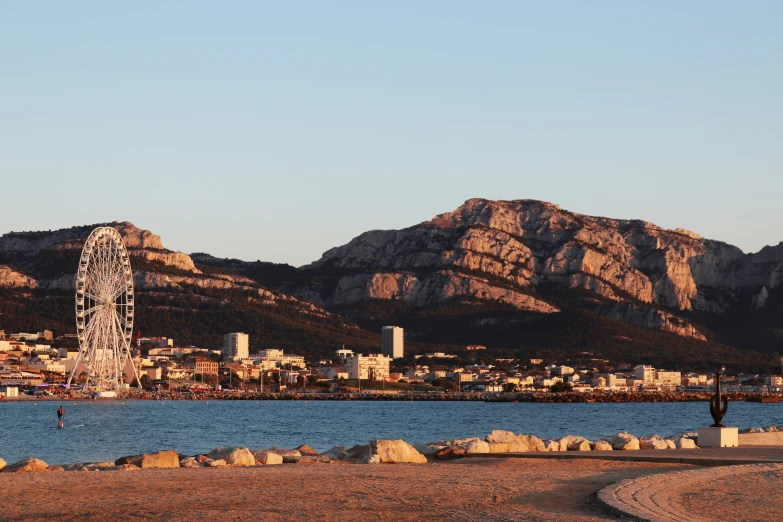 the view of a mountain range with a ferris wheel in front