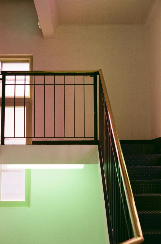 a staircase with railing and windows in a room