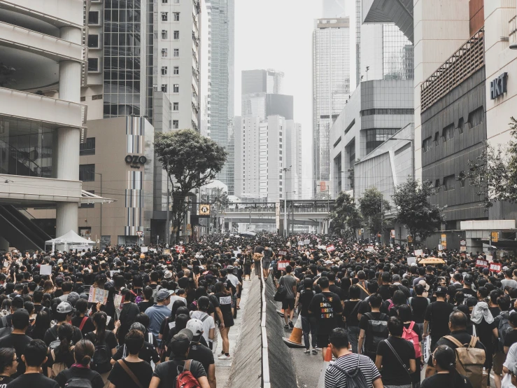 a crowd of people walk down the street