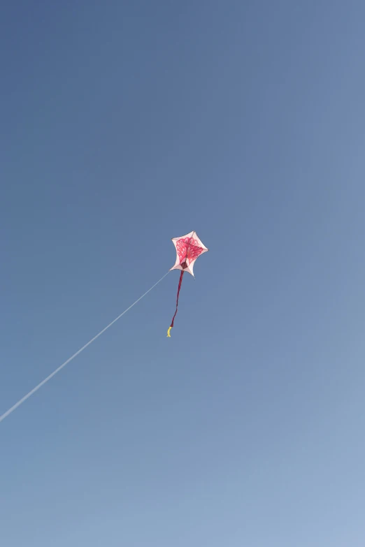 a pink kite being flown by a person