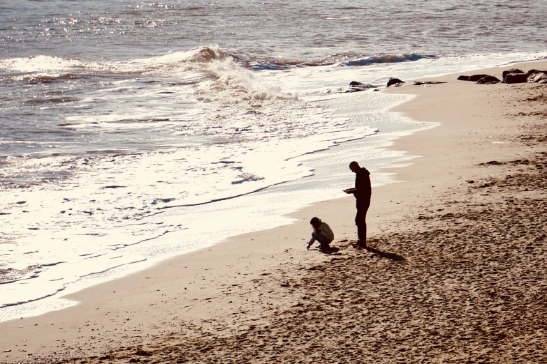 two people are at the beach with the ocean in the background