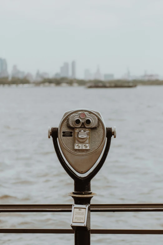 a coin operated parking meter in front of the water