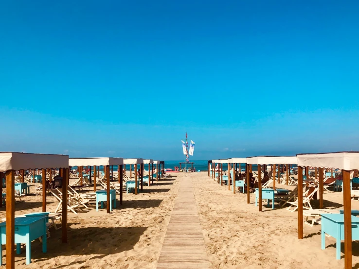 a sandy beach with chairs and umbrellas on a sunny day