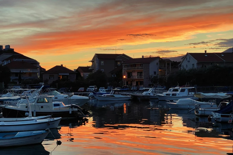 many boats are docked in the water at sunset