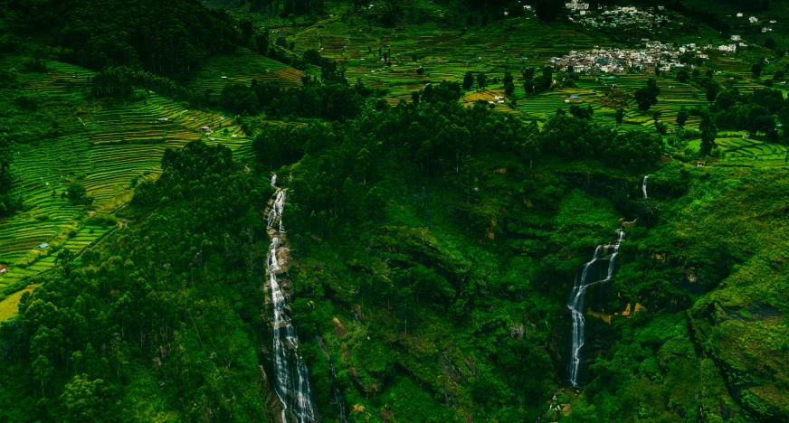 an aerial po of waterfalls and lush green mountains