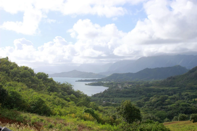 the view of mountains, forests and a lake is shown from a distance