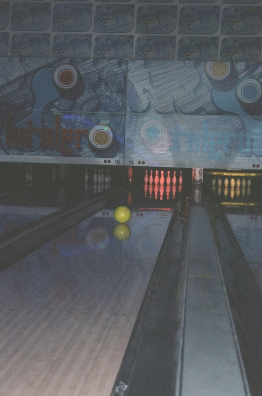 a bowling ball in a bowling alley with another bowling ball in the lanes