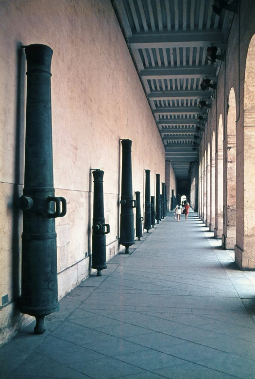 a long line of black pipes next to a building