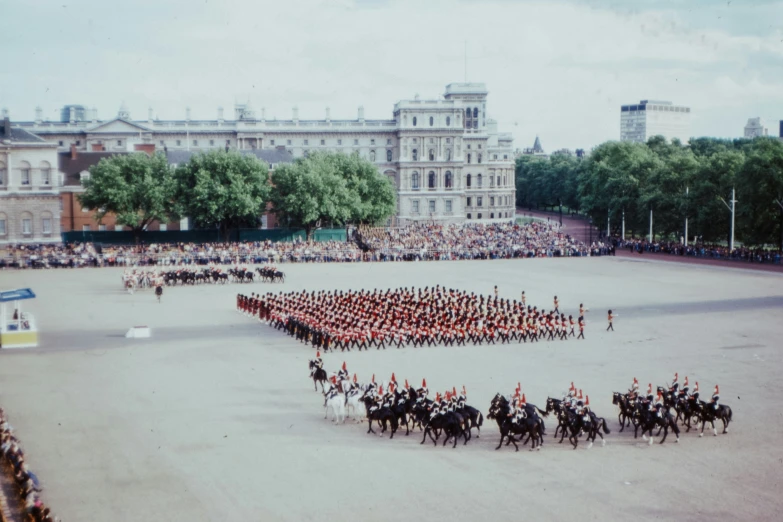 the men in uniform are riding horses through the plaza