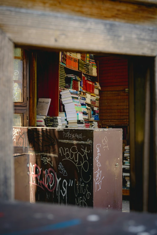 a bookshop filled with lots of books next to a wall