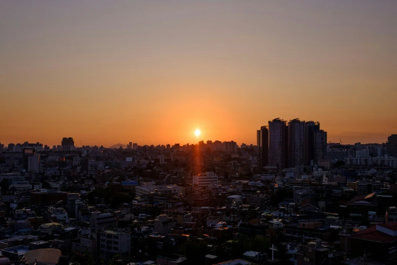 the sun sets over a city that is very tall