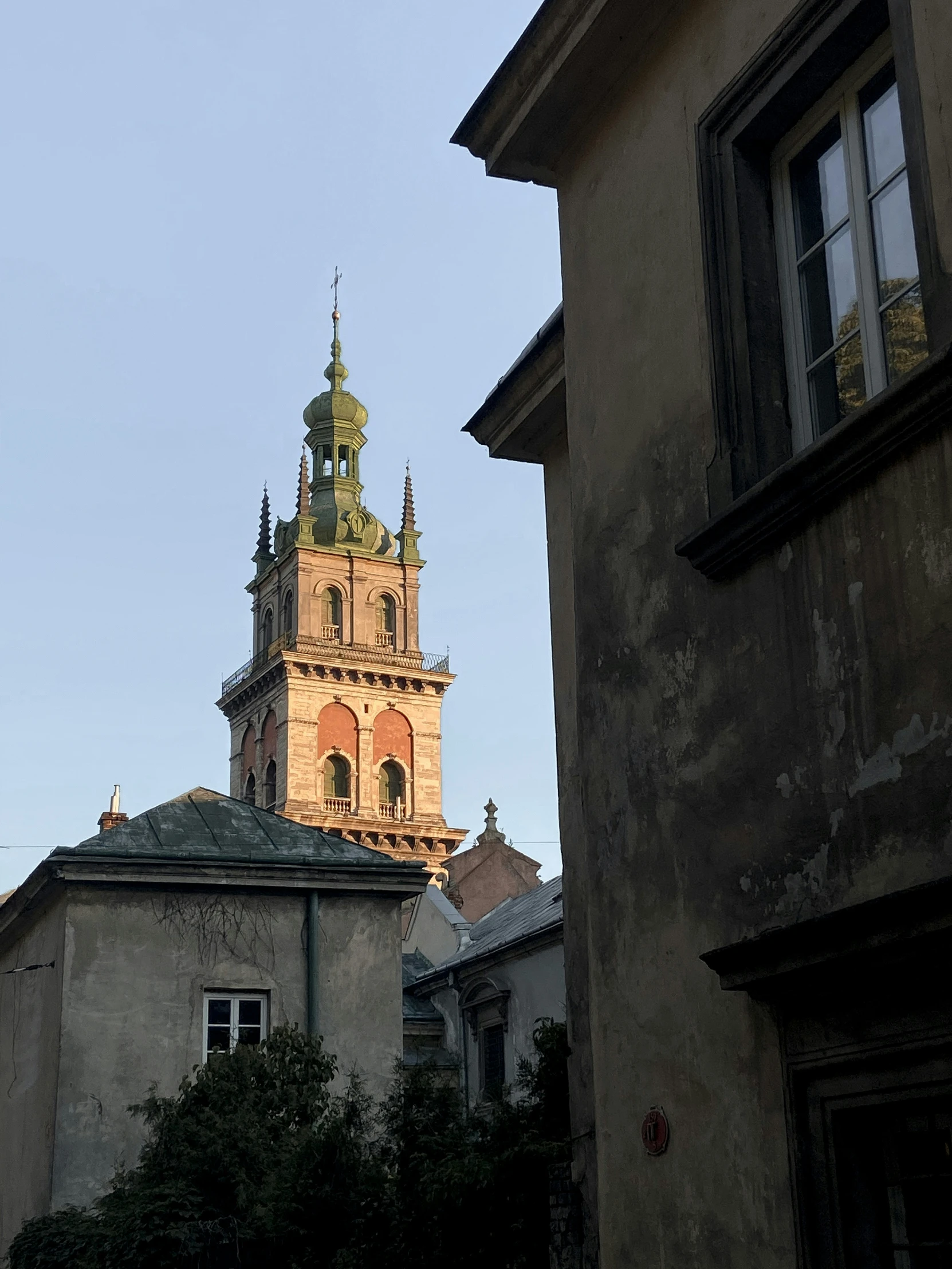 the view of a church steeple from across an alley way